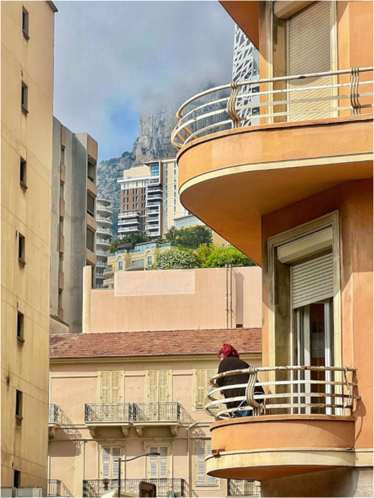 Close-up of framed balcony city photo with orange railing and wooden frame