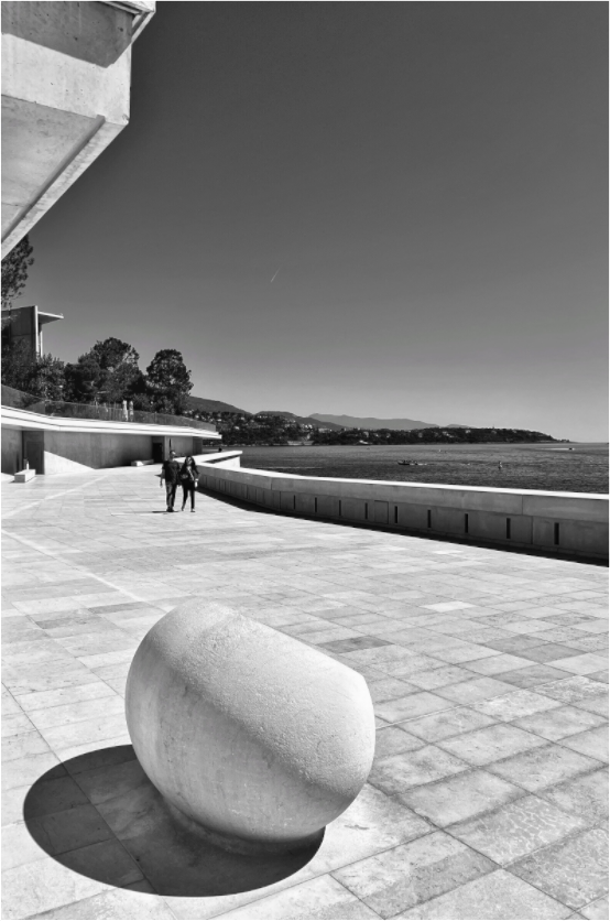 Floater-framed acrylic photo print of black-and-white stone sculpture on seaside walkway