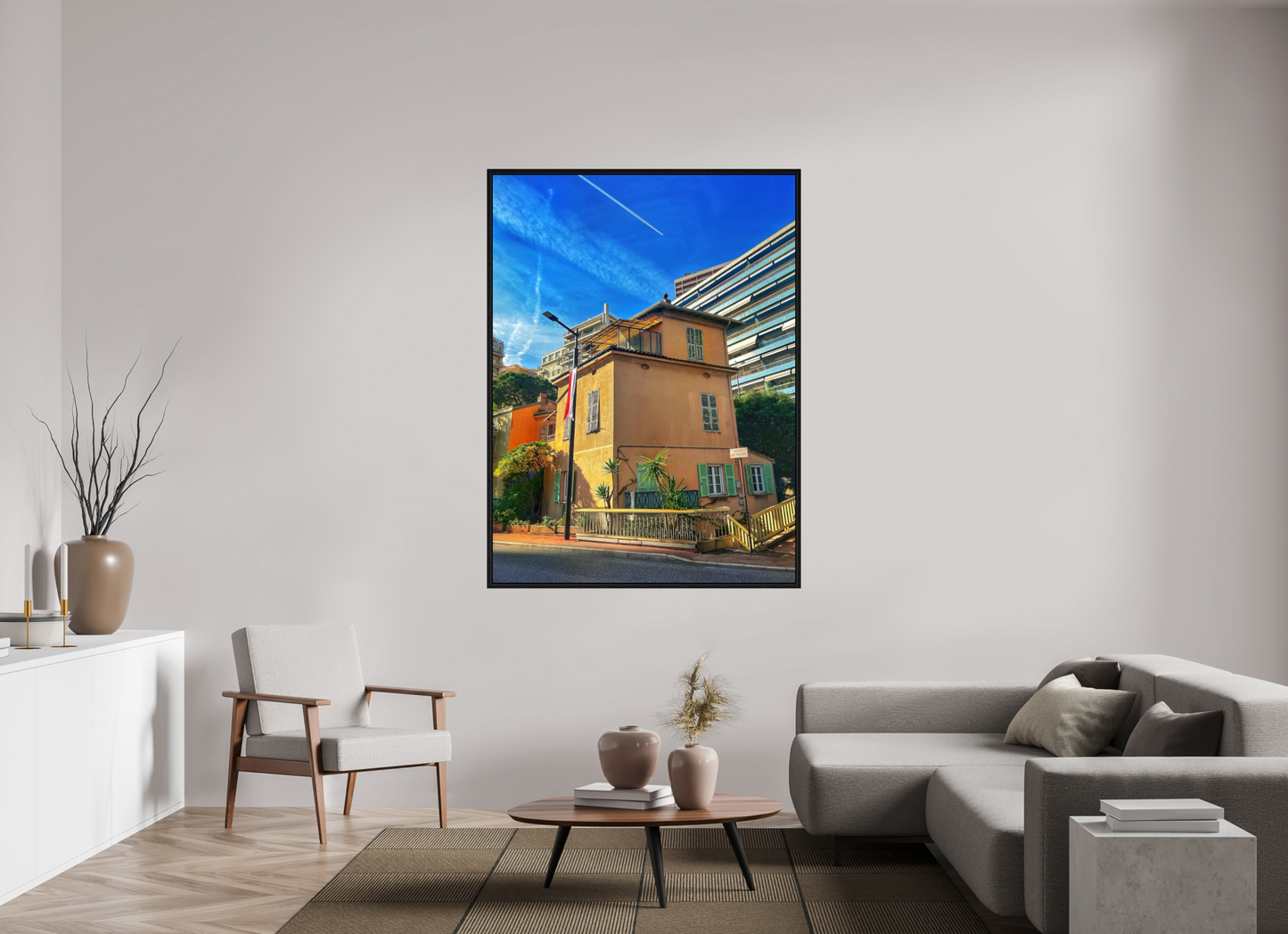 Square framed photo print under acrylic glass showing a yellow house facade and blue sky.