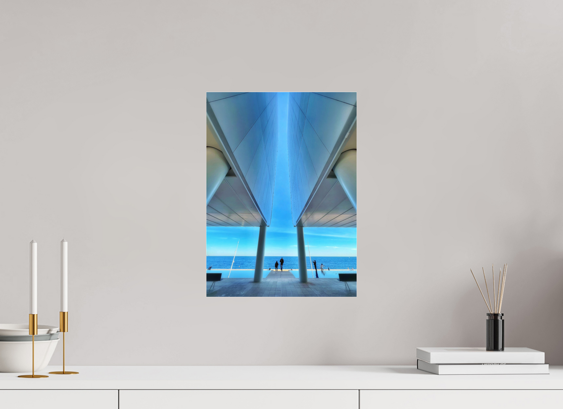 Framed acrylic-glass wall print of blue seaside structure seen between columns