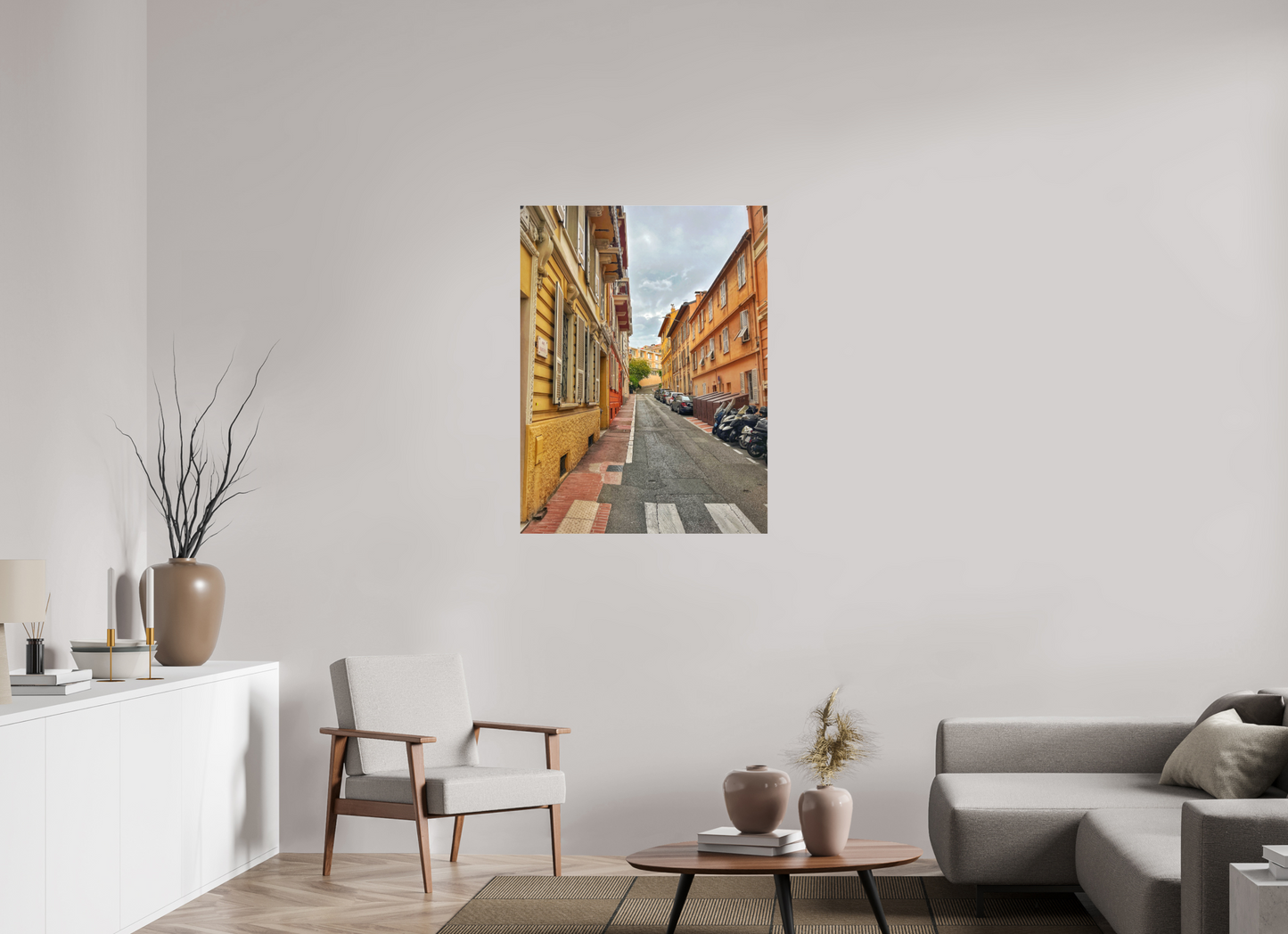 Square street photo print above coffee table, narrow lane with colorful façades