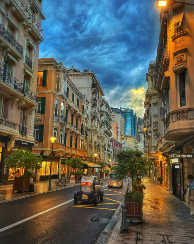 Wall-mounted city street photo in acrylic glass floater frame, blue stormy sky
