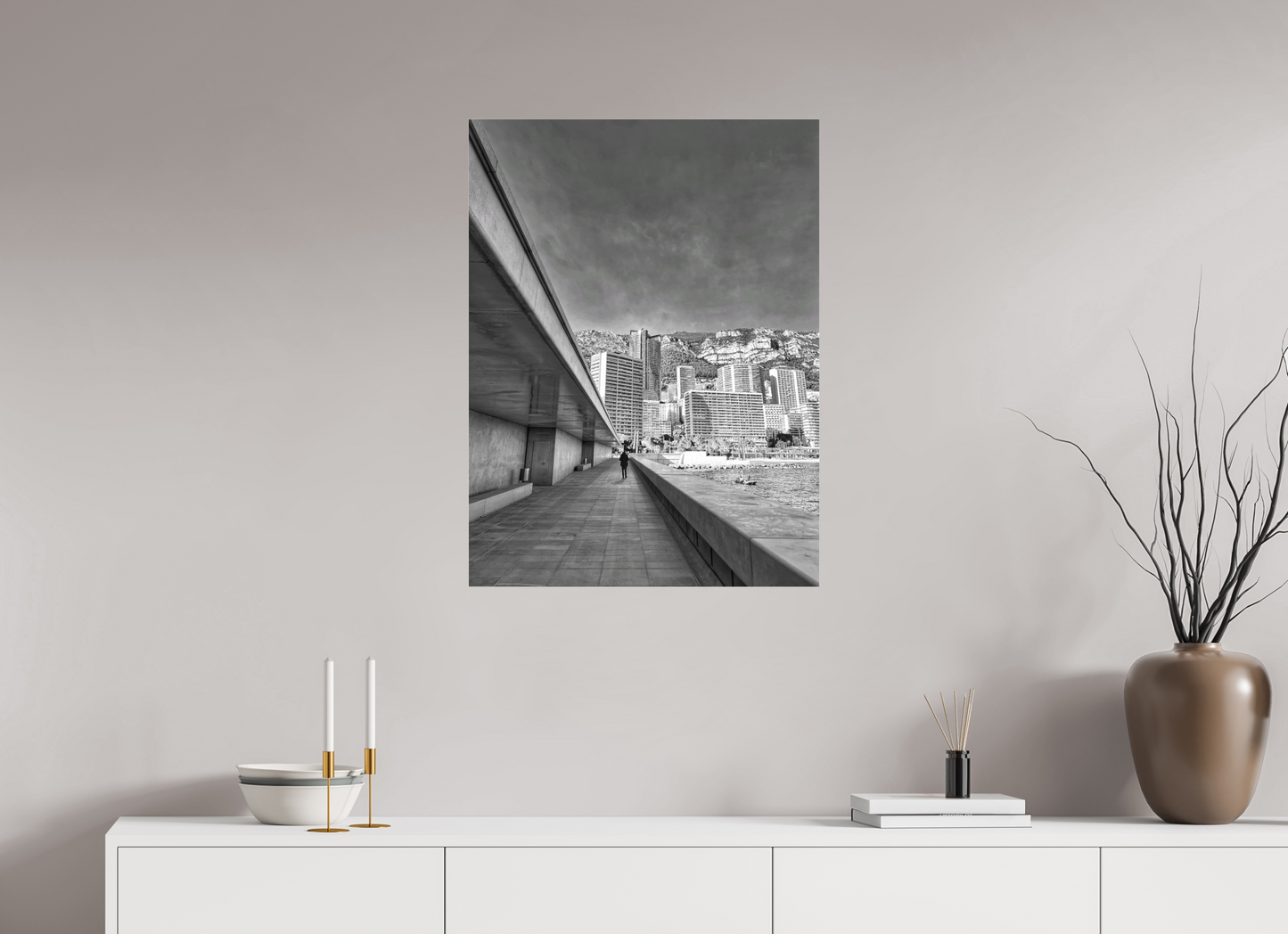 Framed black-and-white city street photo print above console and vase