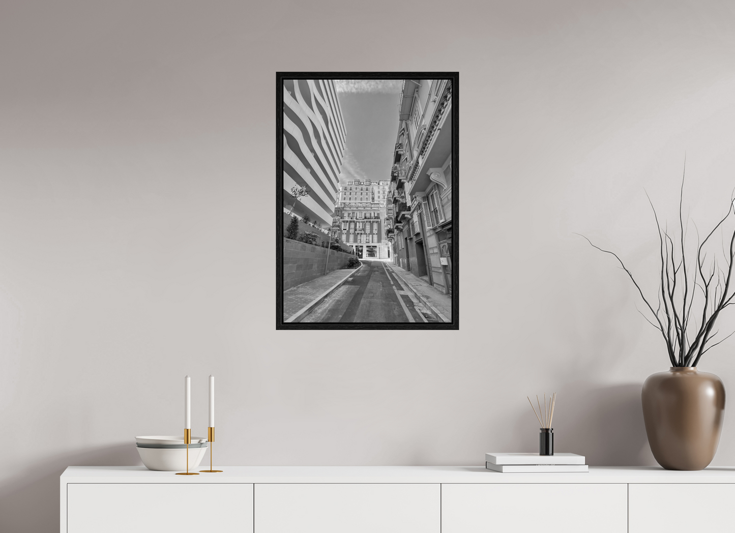 Framed black-and-white street photo print showing a long road between tall buildings
