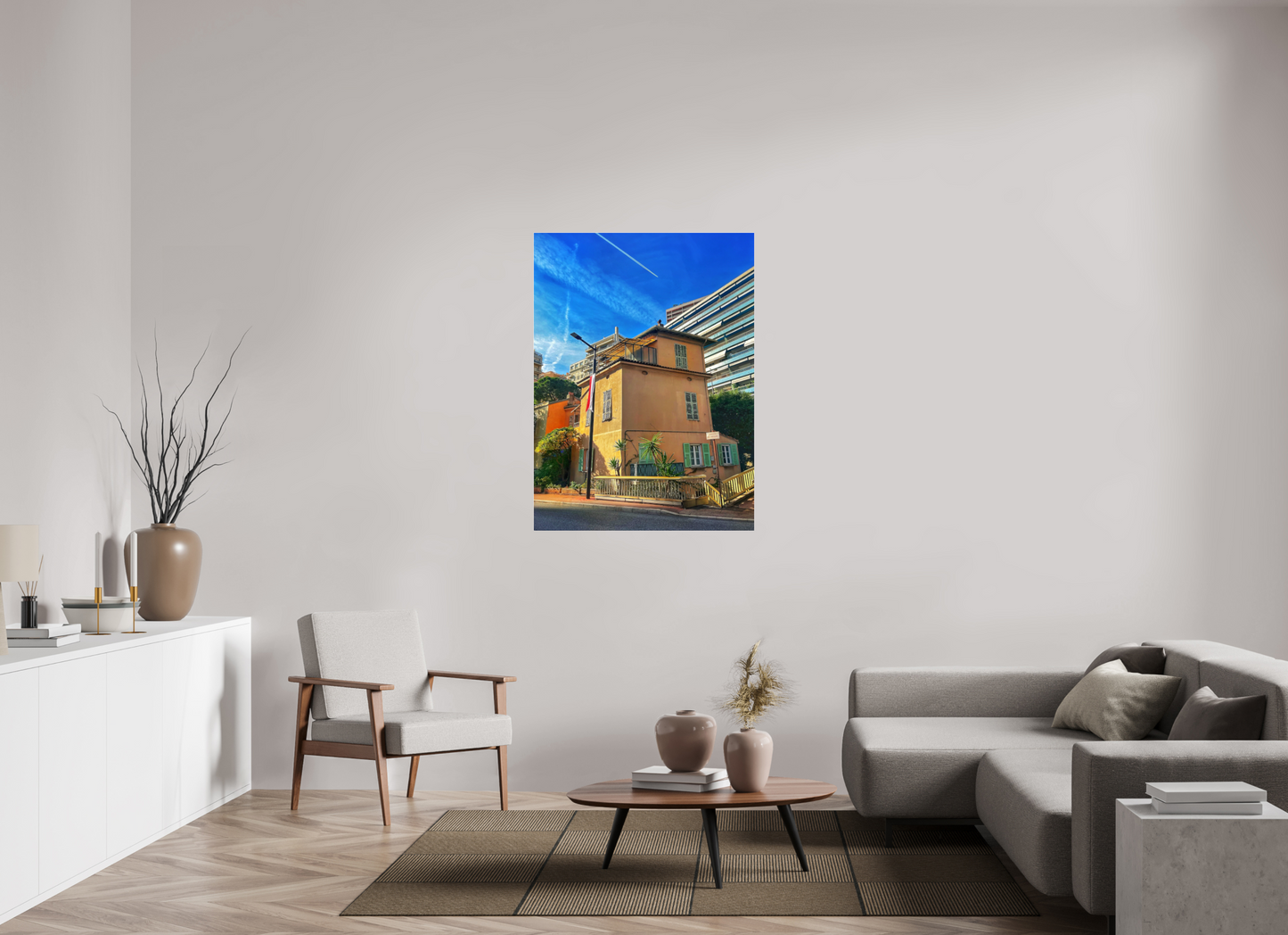Square framed photo print under acrylic glass showing a yellow house facade and blue sky.